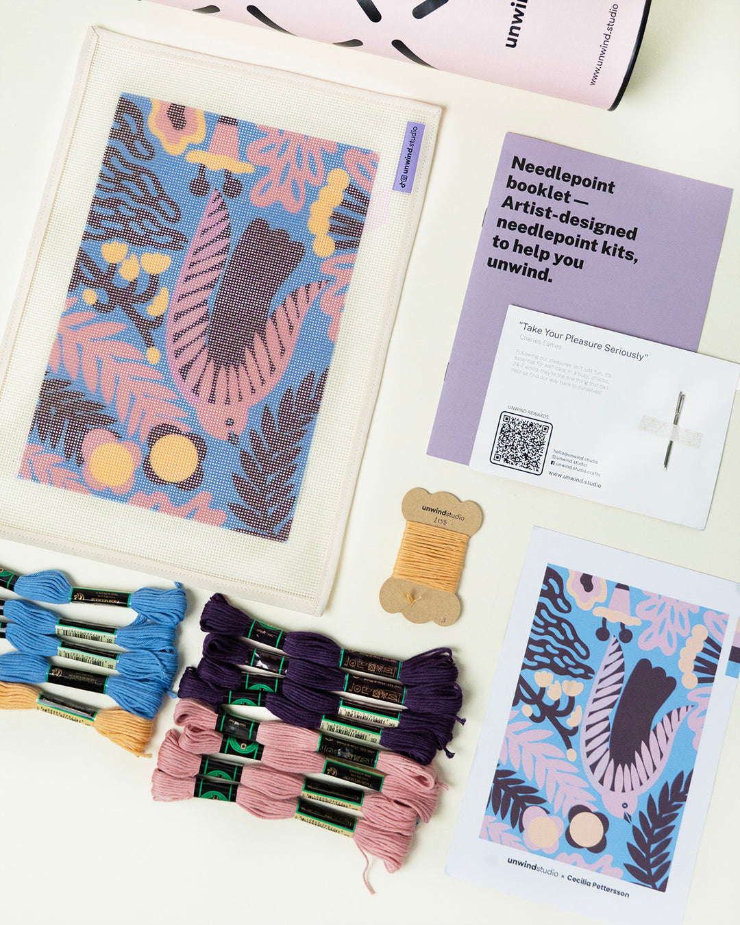 Needlepoint kit with patterned cards and yarn on a white surface