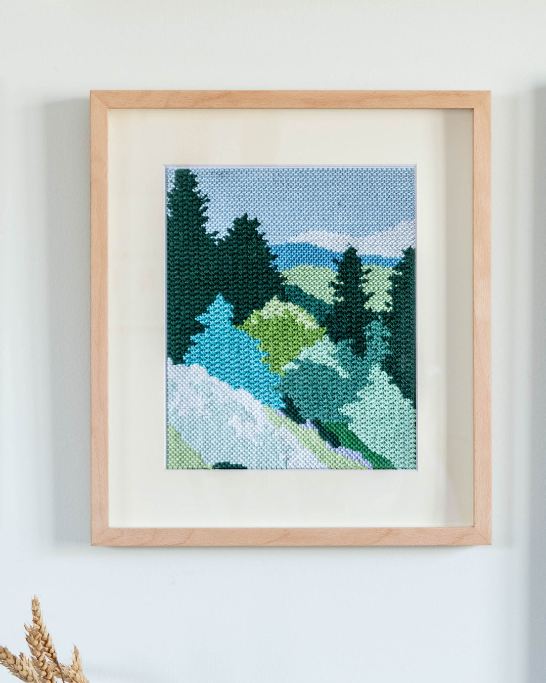 needlepoint painting with mountains and forest