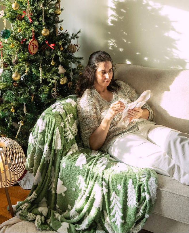 woman relaxing while stitching a needlepoint kit in a christmas scenario