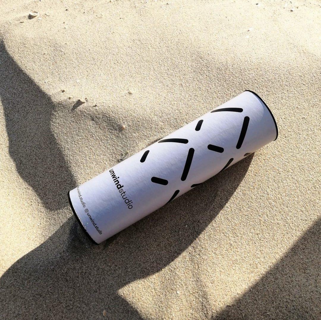Unwind Studio needlepoint kit packaging tube in the beach