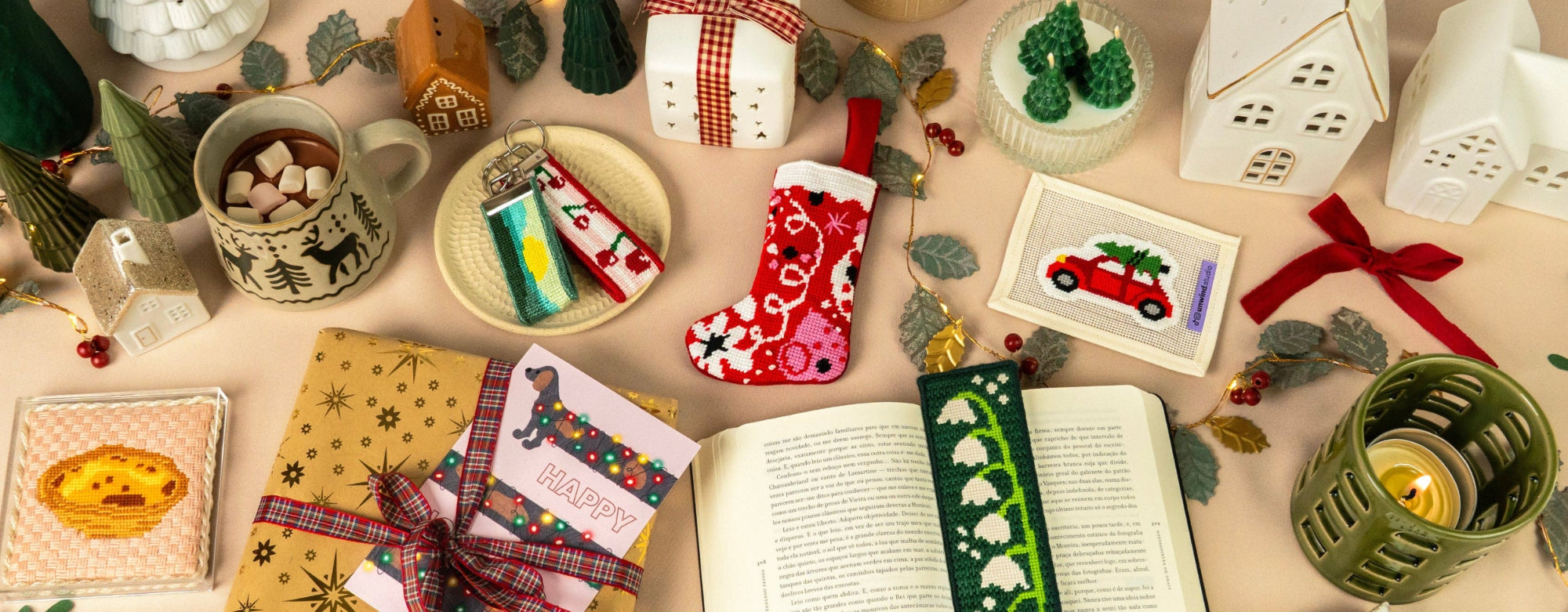 Scatter of Christmas-themed items including mugs, books, and decorative objects on a table.