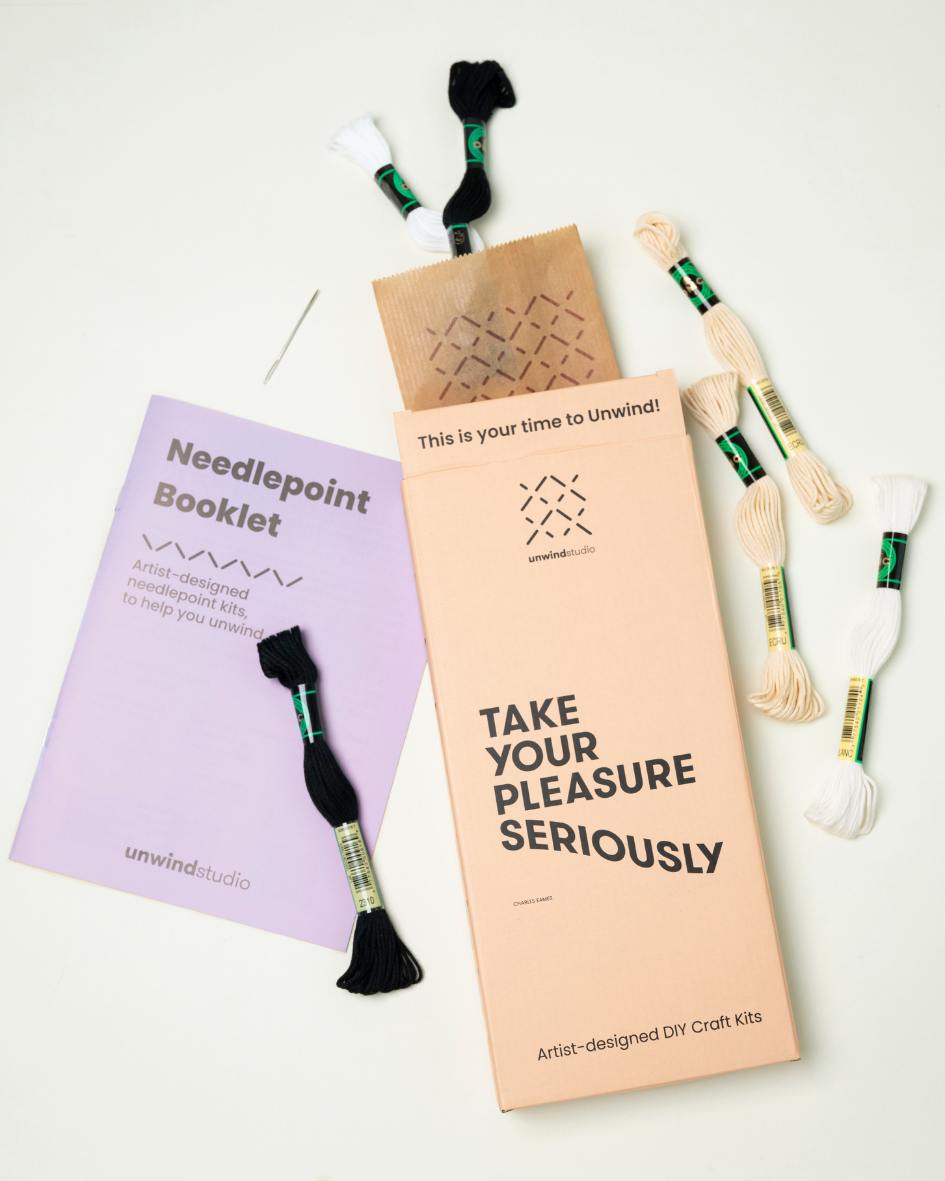 Unwind studio bookmark packaging displayed in a flat lay with exemples of threads and a instructional booklet