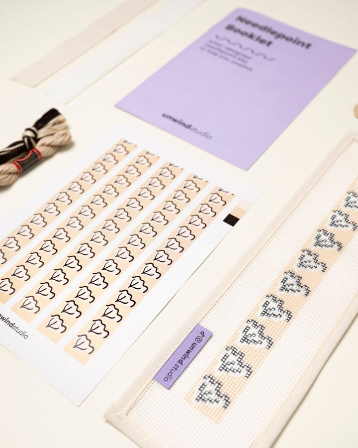 diagonal view of the Clay View Key Fob Needlepoint Kit with printed canvas, matching threads and finishing materials and a instructional booklet
