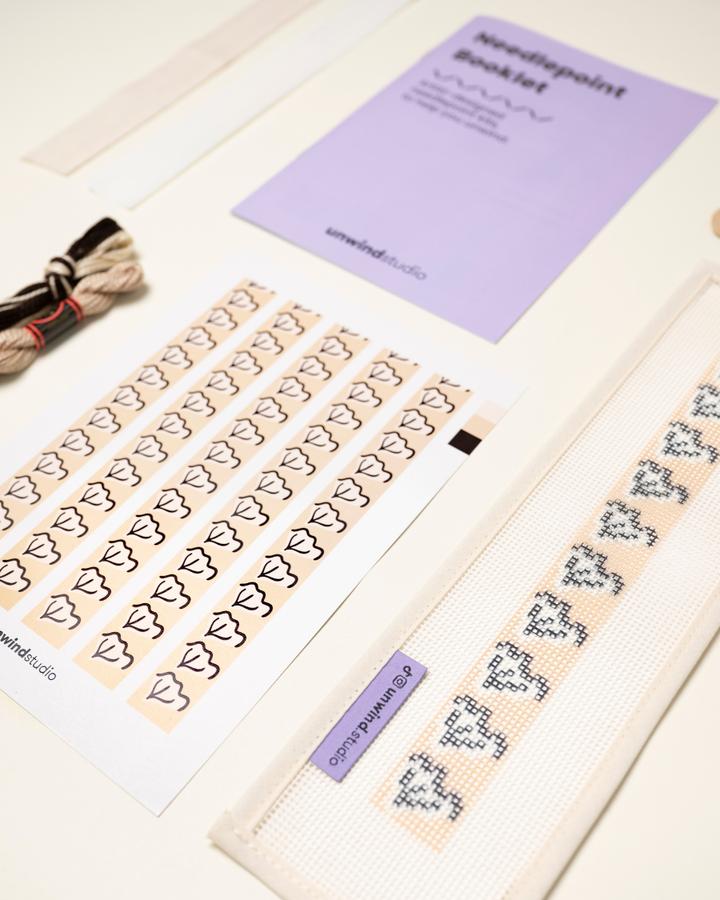 diagonal view of the Clay View Key Fob Needlepoint Kit with printed canvas, matching threads and finishing materials and a instructional booklet