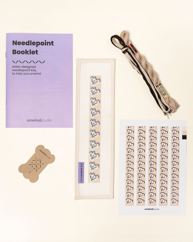 flat view of the Clay Leaf Key Fob Needlepoint Kit with printed canvas, matching threads, a instructional booklet and a graphic flyer
