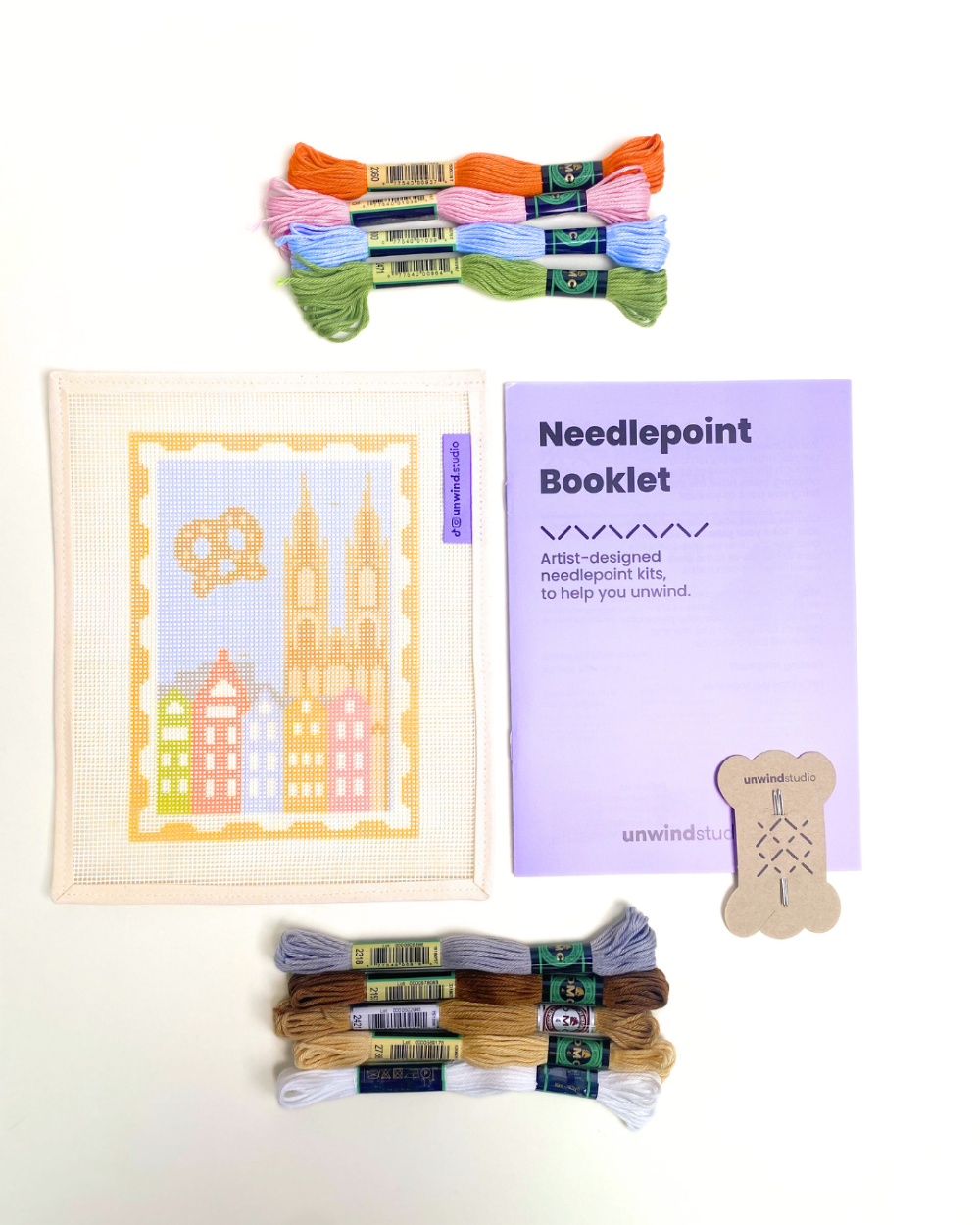 Cologne Stamp Needlepoint Kit paired with a booklet, threads and needles