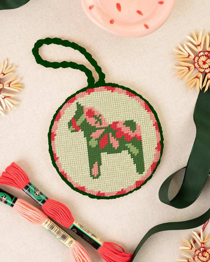 Dala Horse Green Ornament finished and placed next to soft christmas elements and matching threads