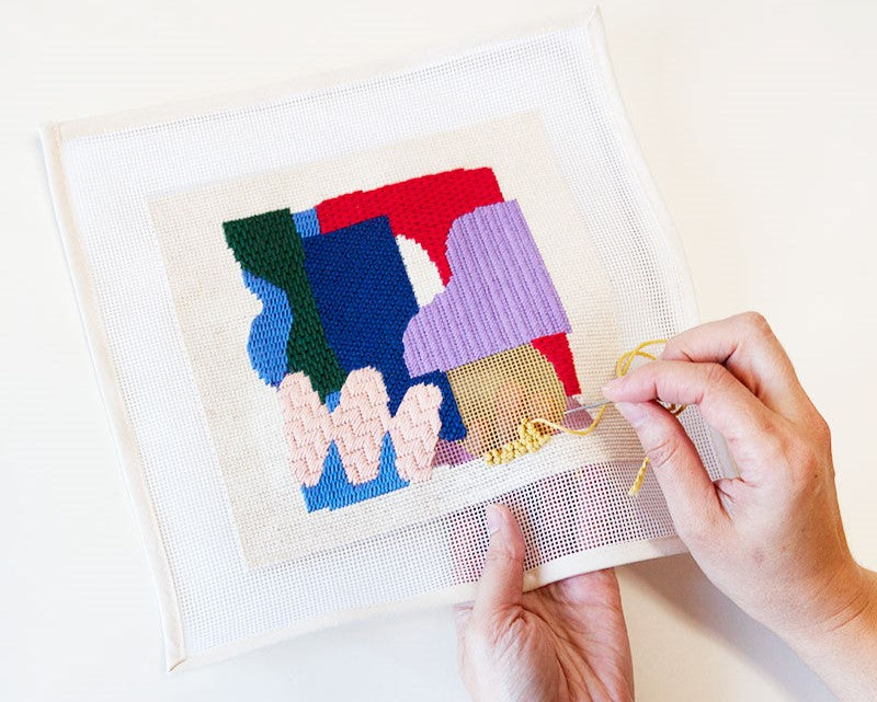 colorful abstract needlepoint pattern being stitched