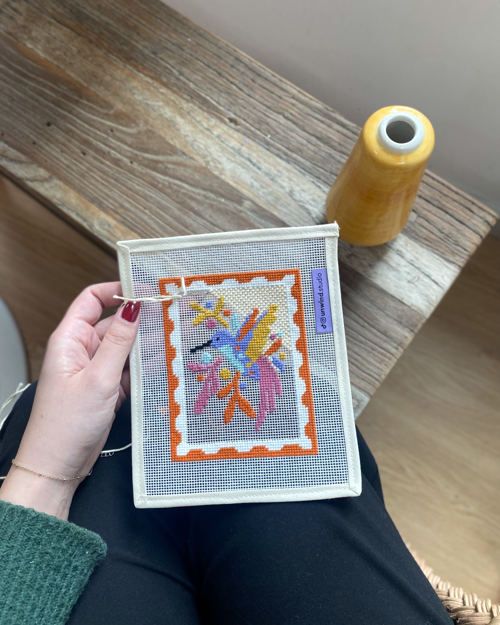 Hummingbird needlepoint canvas in progress with needle and thread.