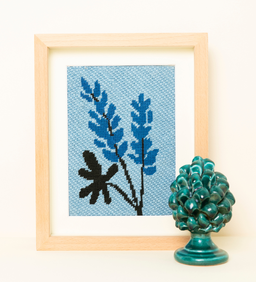Lupin Needlepoint Kit placed on a wood frame with a green decorative element.