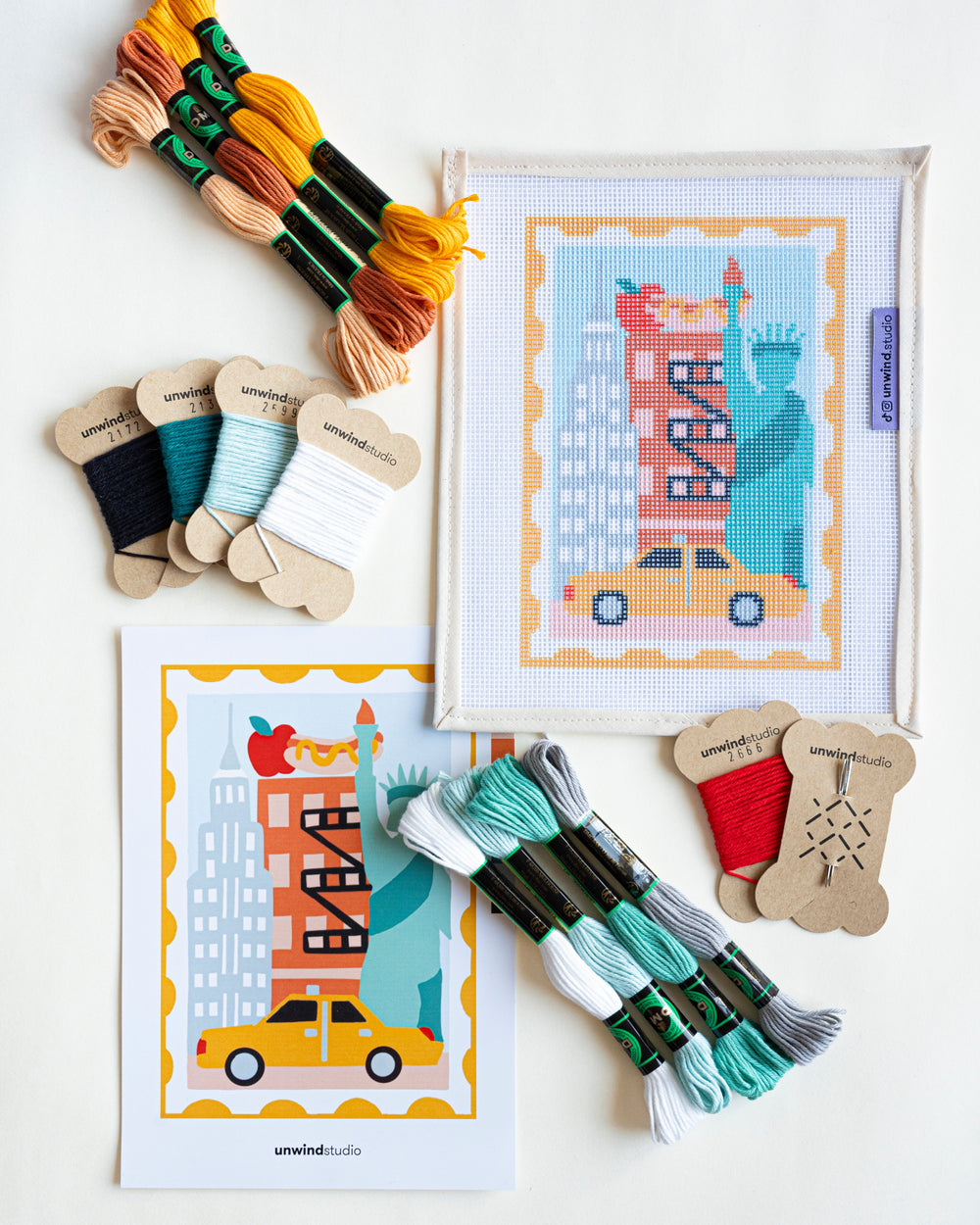 Overview of the New York Stamp Complete Needlepoint Kit with threads and needle.