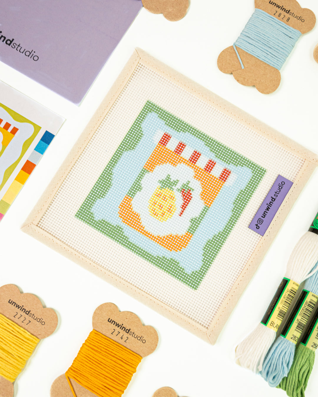 Close-up perspective of the Pineapple & Chili Jam Coaster needlepoint kit, showing the harmony between the colorful canvas patterns and the curated thread palette