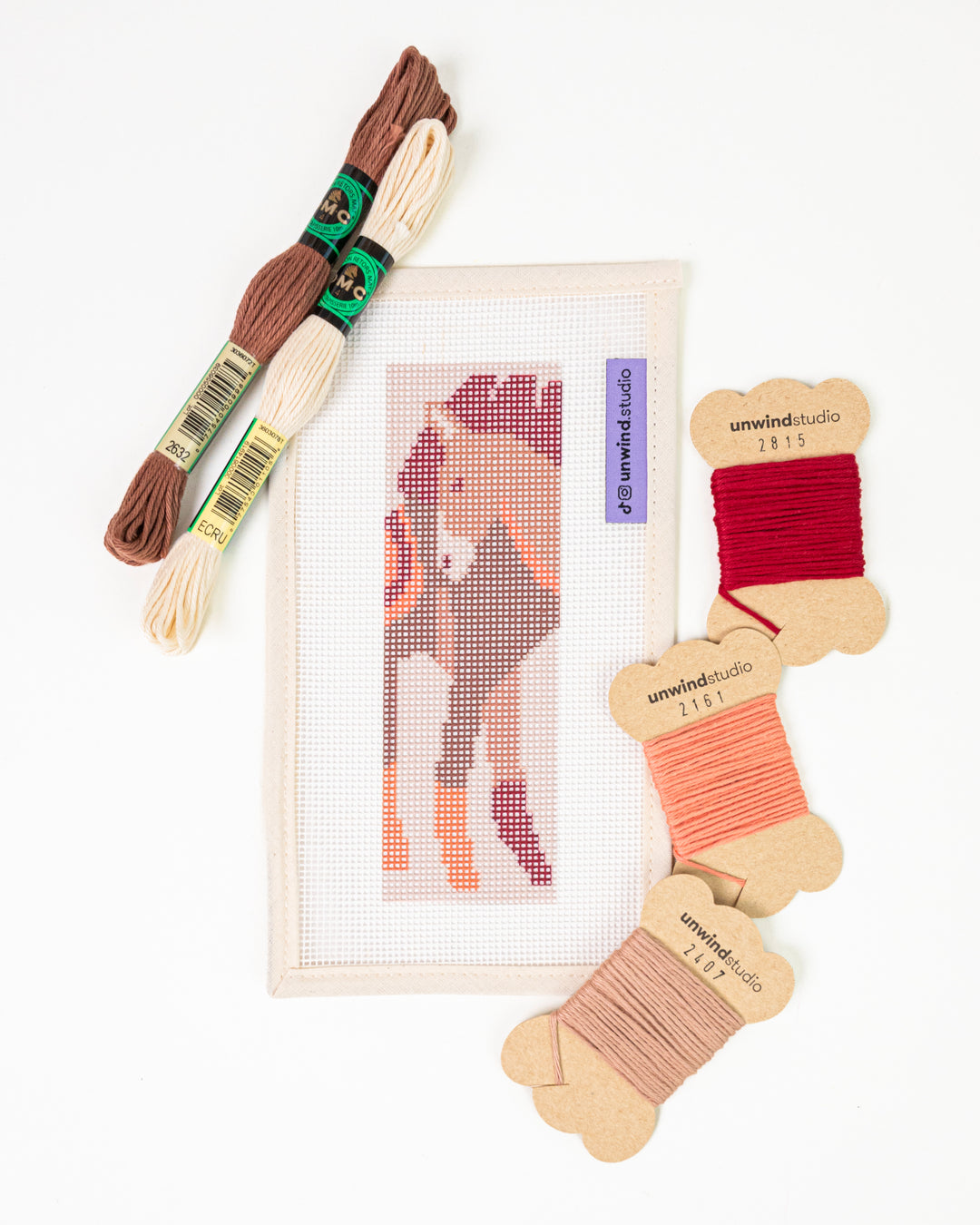The Horse Spirit needlepoint bookmark kit with a beautiful horse design on a pastel background, surrounded by kit DMC Soft Cotton Threads.