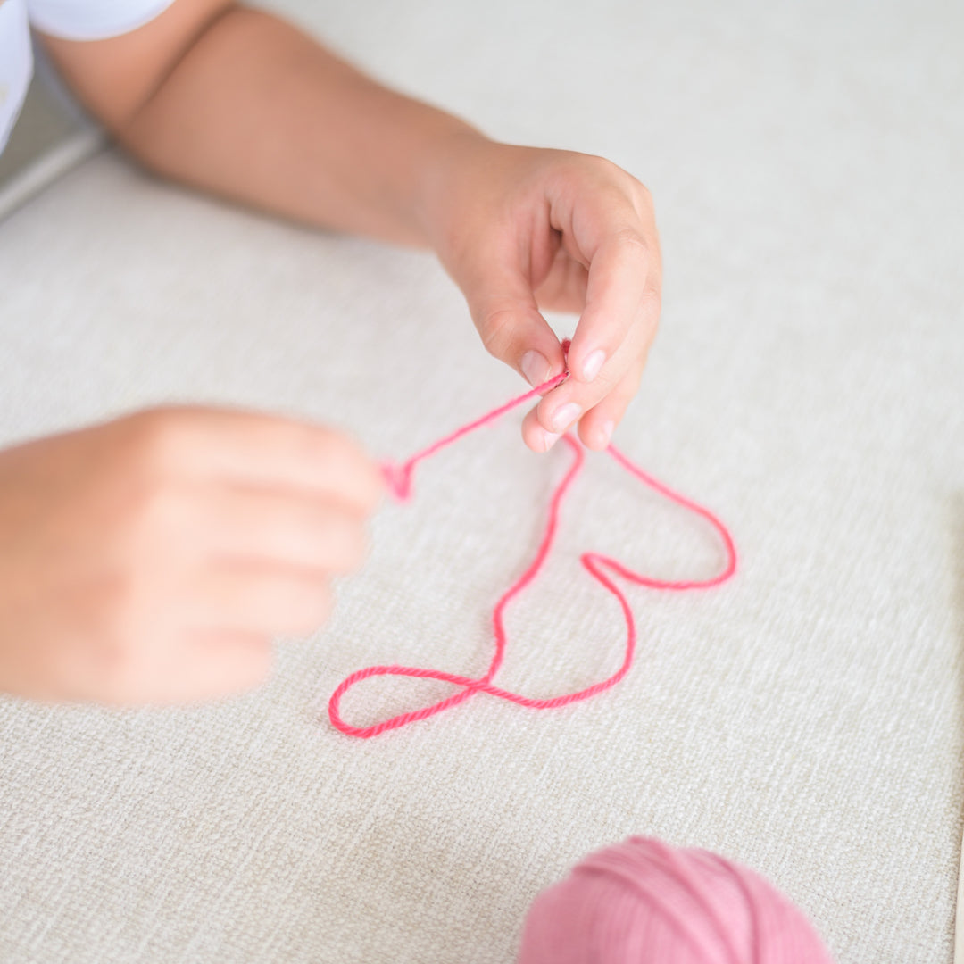 kid hands threading the thread in a needle