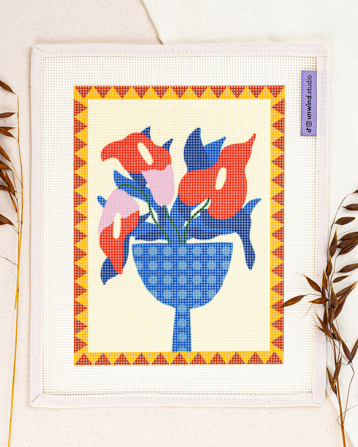 anthurium needlepoint kit by teresa rego: printed canvas of red flowers on blue, framed with dried twigs