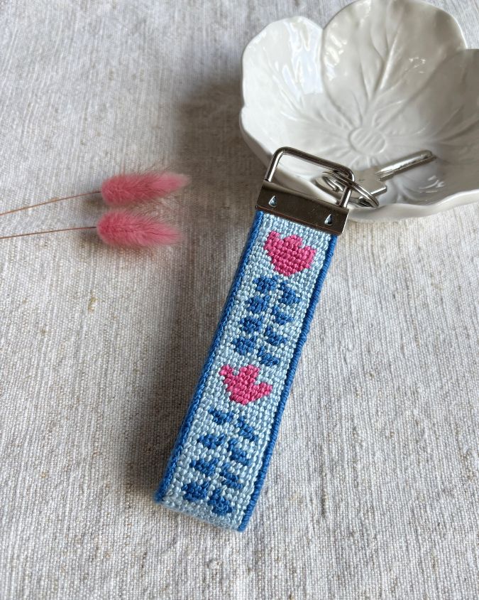 Berry Vine Key Fob Needlepoint Kit placed on top of a bowl with a dry flower on its side
