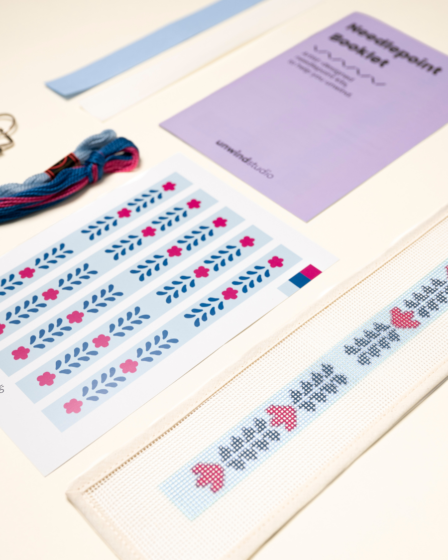 diagonal view of the Berry Vine Key Fob Needlepoint Kit with printed canvas, matching threads and finishing materials and a instructional booklet
