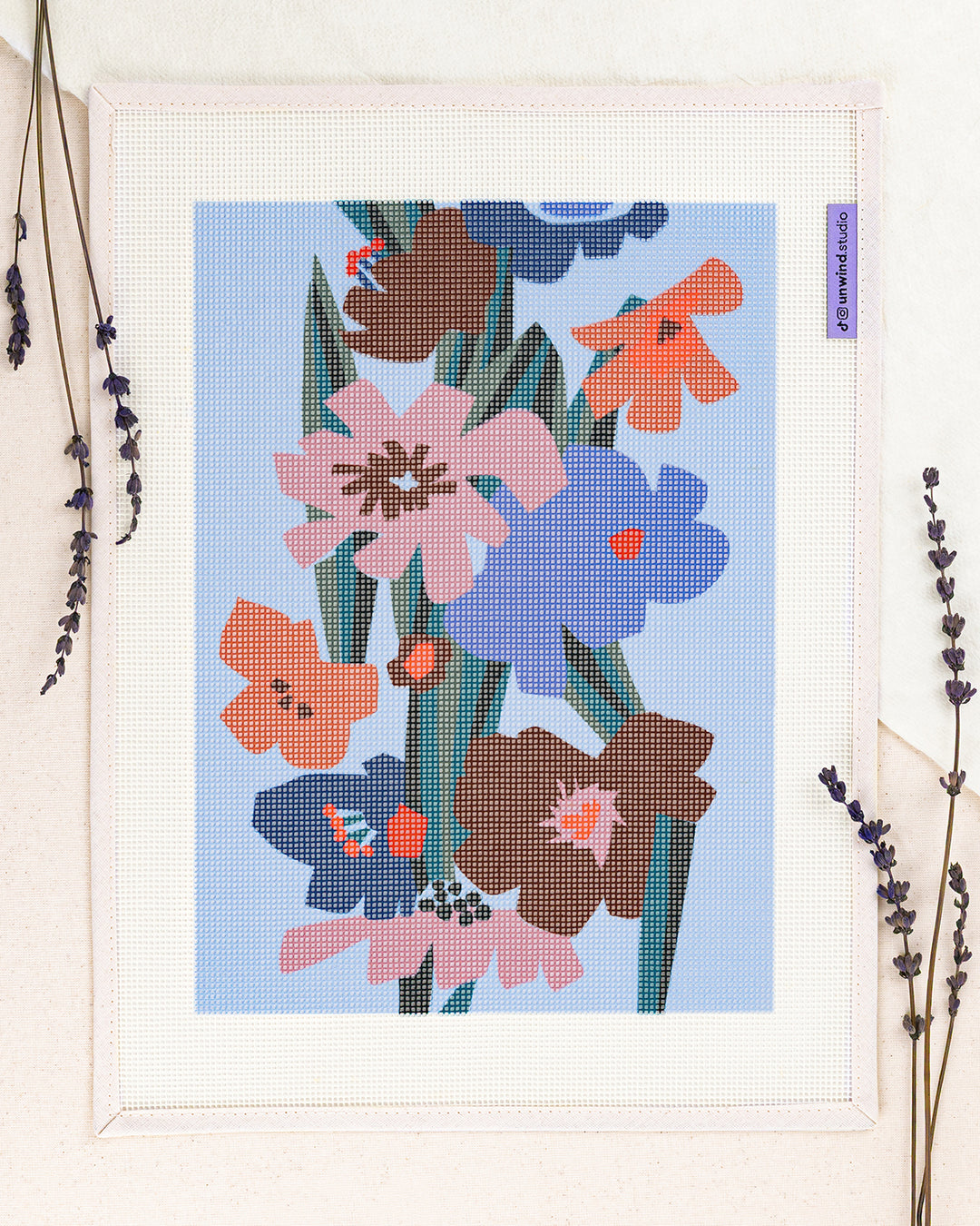 Blooming in the dark needlepoint kit by Ophelia Pang: printed canvas of dark color flowers on blue, framed with dried twigs