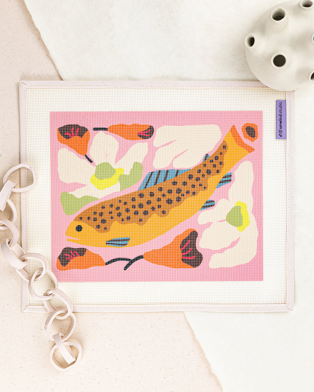 brook trout needlepoint kit by bekah worley: printed canvas of orange fish on pink, framed with dried twigs