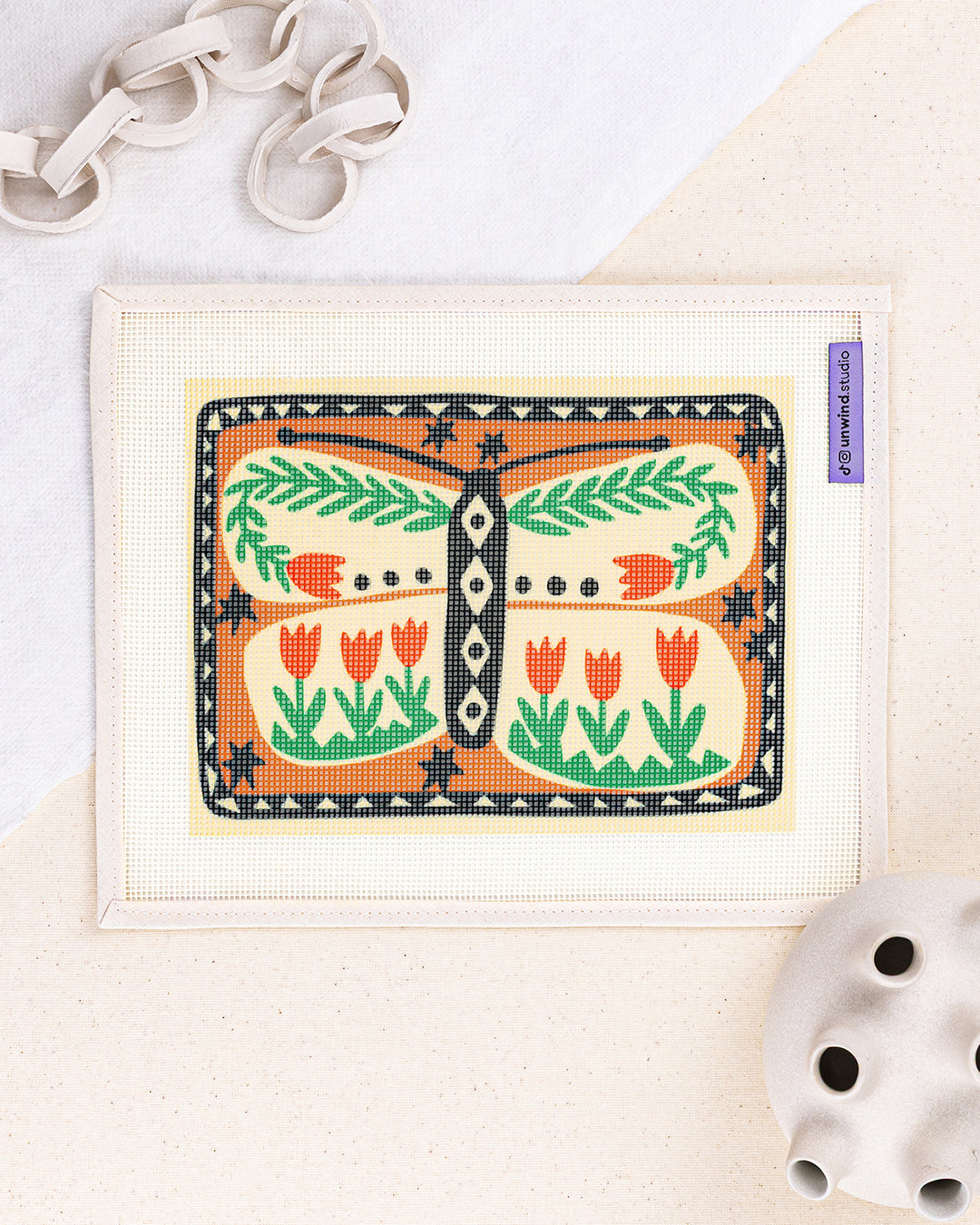 folk butterfly needlepoint kit by carole hillman: printed canvas of a folk butterfly, framed with white decor