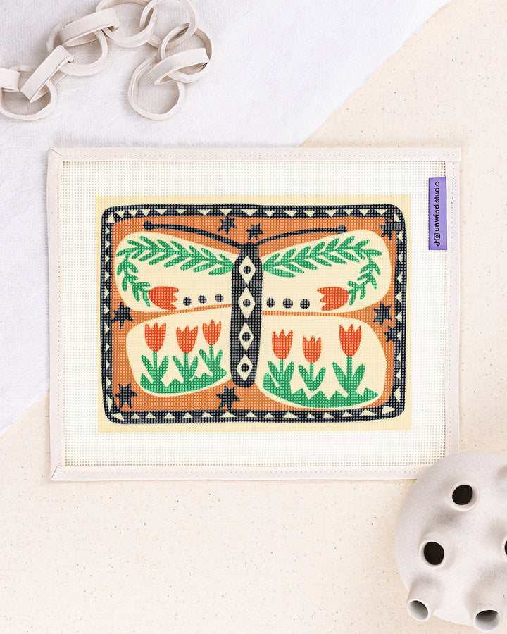 folk butterfly needlepoint kit by carole hillman: printed canvas of a folk butterfly, framed with white decor