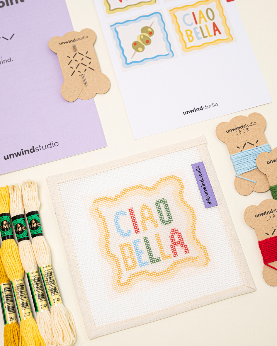 diagonal flat lay of the ciao bella coaster paired with matching DMC soft cotton threads.