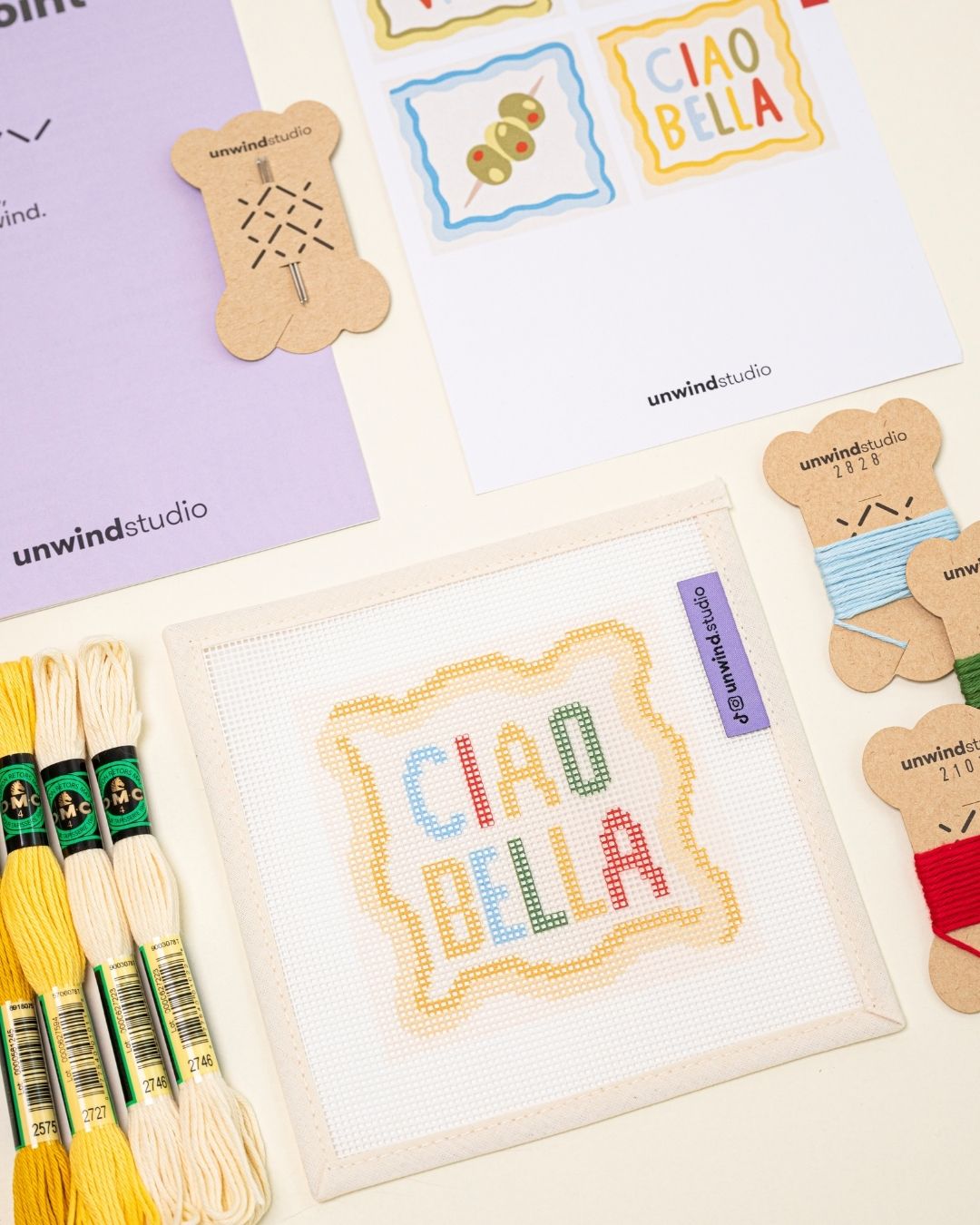 diagonal flat lay of the ciao bella coaster paired with matching DMC soft cotton threads.