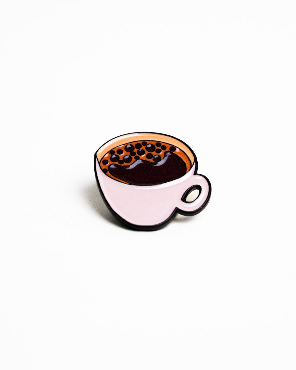 up-close shot of the unwind studio needle minder coffee (bica) magnet (enamel pin).

