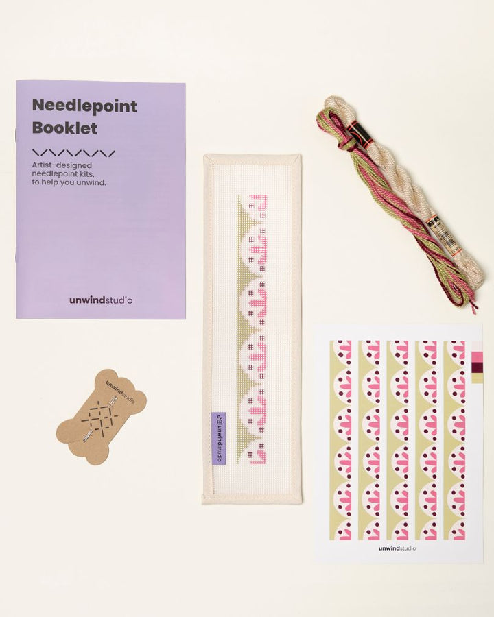 flat view of the Flourish Key Fob Needlepoint Kit with printed canvas, matching threads, a instructional booklet and a graphic flyer
