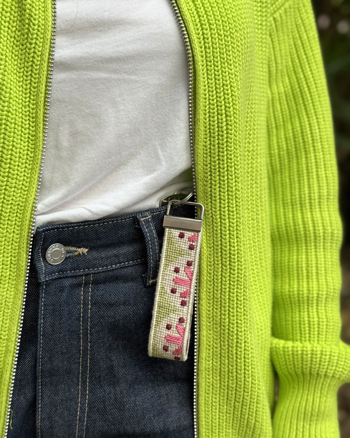 Flourish Key fob with denim jeans and a bright green jacket