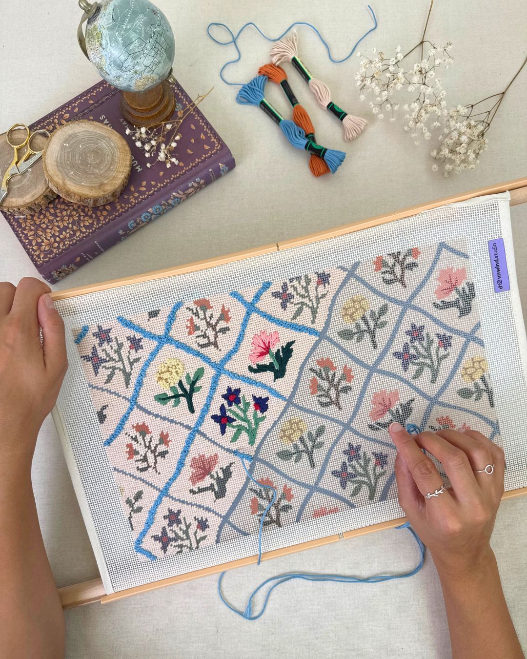 flower diamonds needlepoint cushion being stitched in a themed regency and cozy background with the matching threads showing