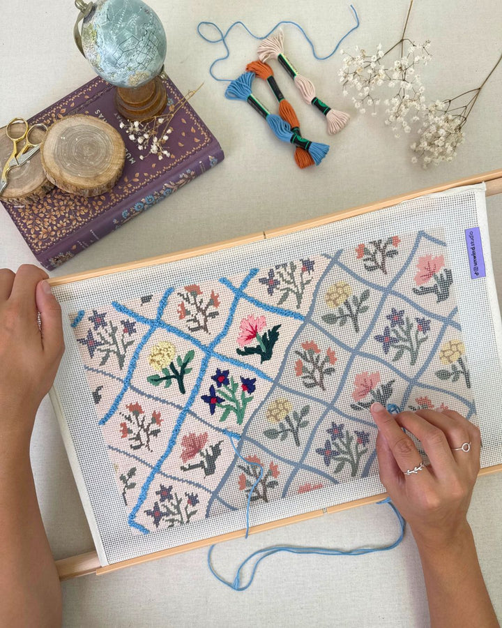 flower diamonds needlepoint cushion being stitched in a themed regency and cozy background with the matching threads showing