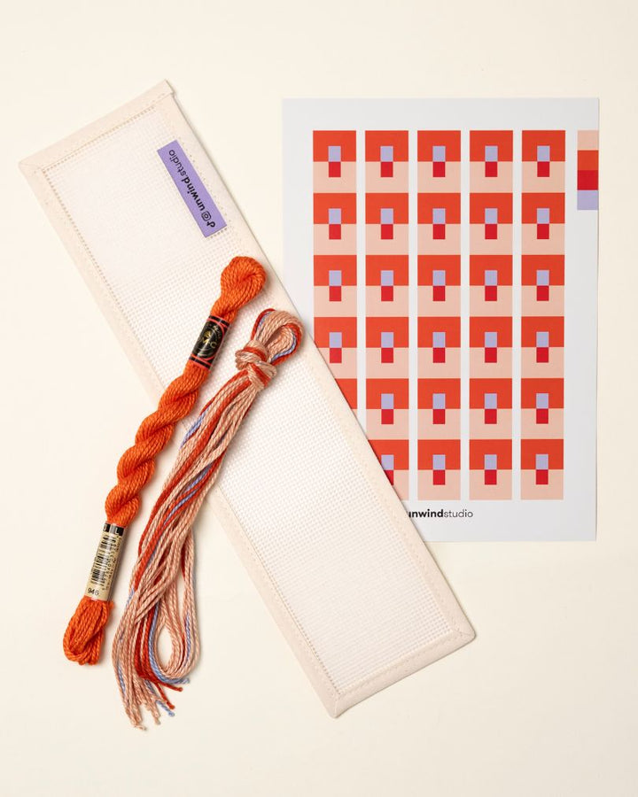 flat view of the Focus Key Fob Needlepoint Kit with blank canvas, matching threads and a graphic flyer
