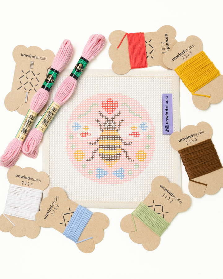 flat view of the folk Bee needlepoint canvas with matching bold colored threads  


