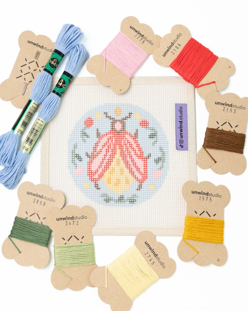 flat view of the folk beetle needlepoint canvas with matching bold colored threads  
