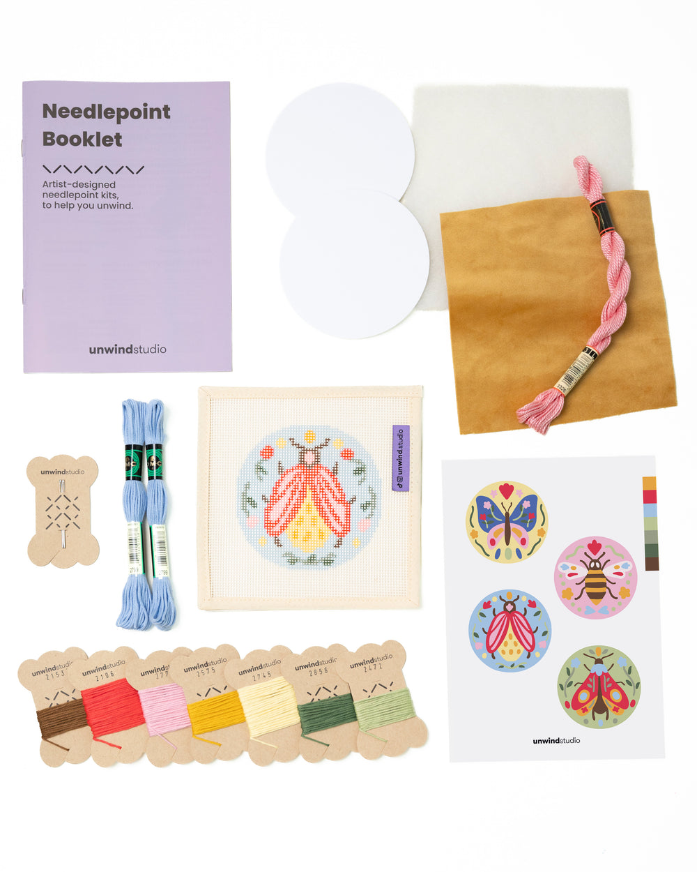 Flat view of the Folk Beetle Needlepoint Ornament by Unwind Studio with everything that comes with the kit: an instructional booklet, needle, dmc soft cotton threads, finishing materials and a graphic flyer

