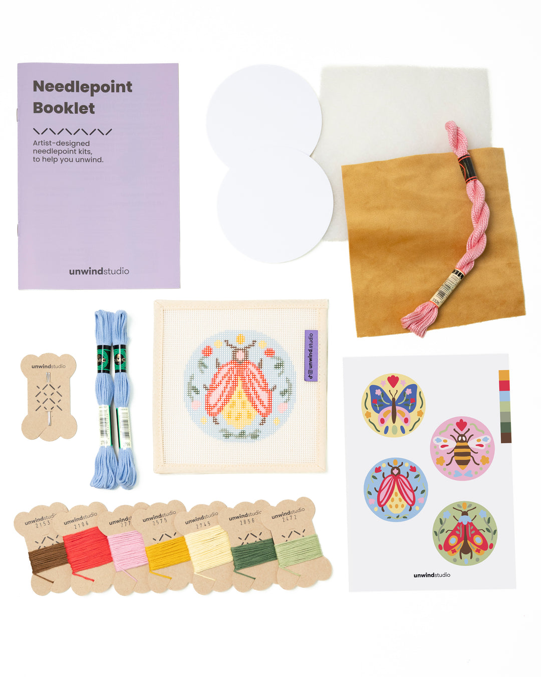 Flat view of the Folk Beetle Needlepoint Ornament by Unwind Studio with everything that comes with the kit: an instructional booklet, needle, dmc soft cotton threads, finishing materials and a graphic flyer

