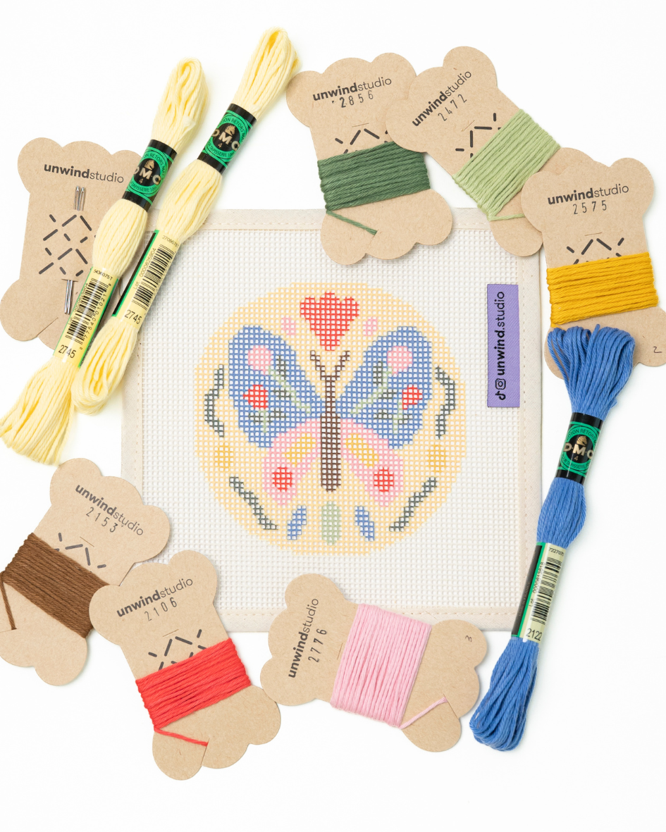 flat view of the folk butterfly needlepoint canvas with matching bold colored threads  


