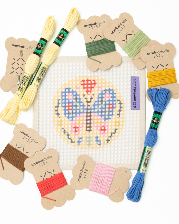 flat view of the folk butterfly needlepoint canvas with matching bold colored threads  

