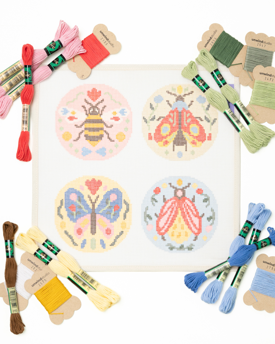 flat view of the Folk Insects Set needlepoint kit with matching threads beside each ornament