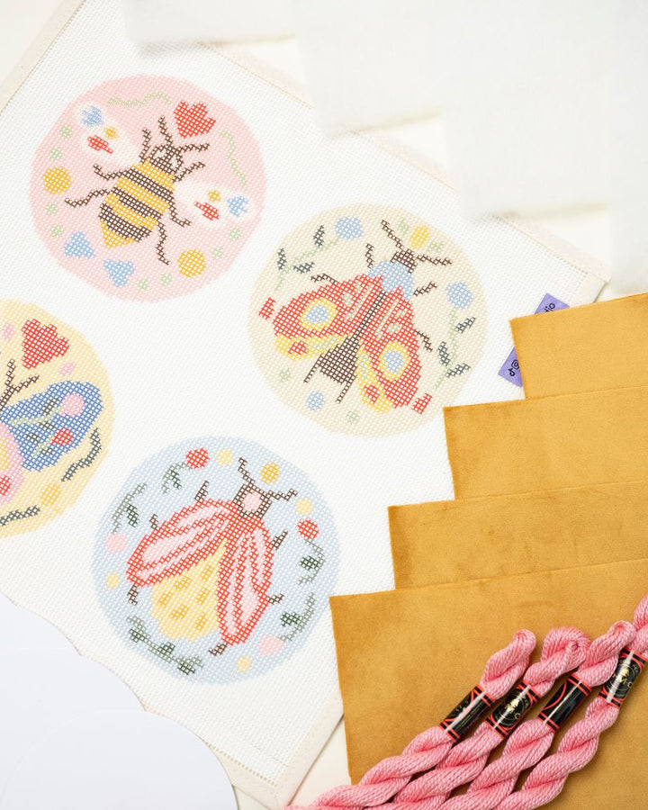 diagonal view of the folk insects with finishing materials - velvet fabric, dmc perle cotton, filling batting
