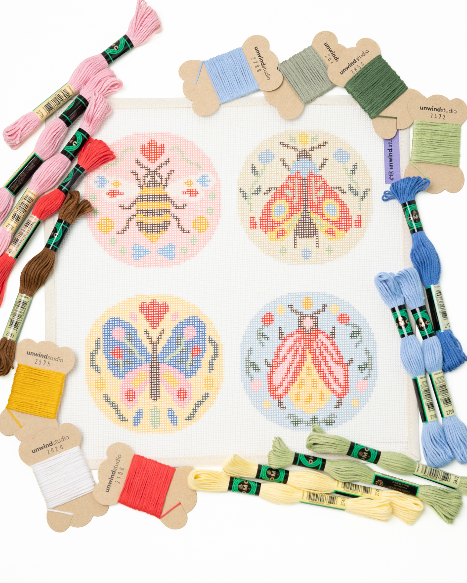 flat view of the folk insects needlepoint set with the matching dmc perle cotton threads