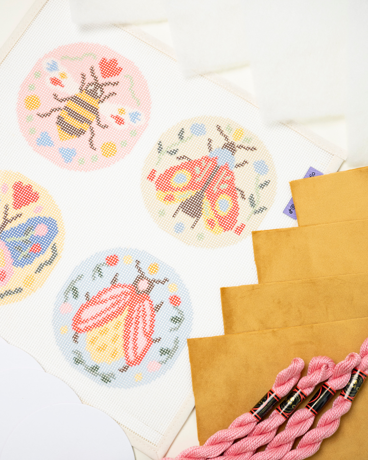 diagonal view of the folk insects with finishing materials - velvet fabric, dmc perle cotton, filling batting