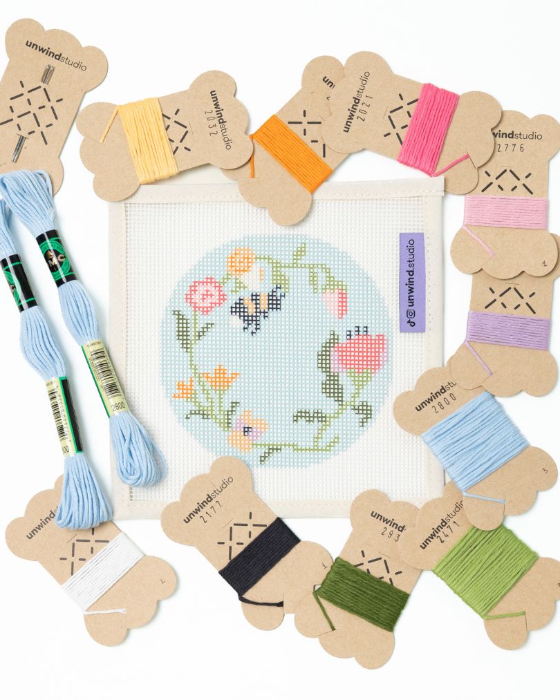 flat view of the Garden bee needlepoint canvas with matching bold colored threads  
