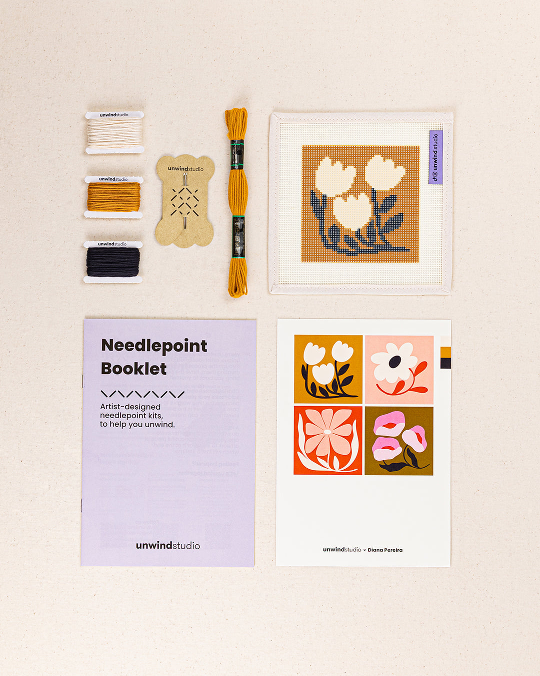Golden Tulips Coaster needlepoint kit contents: printed canvas, threads, needles, and instruction booklet, graphic flyer laid flat