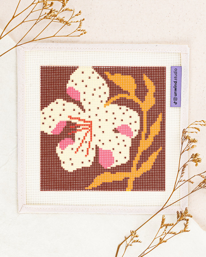 lily needlepoint kit by bekah worley: printed canvas of yellow flowers on blue, framed with dried twigs