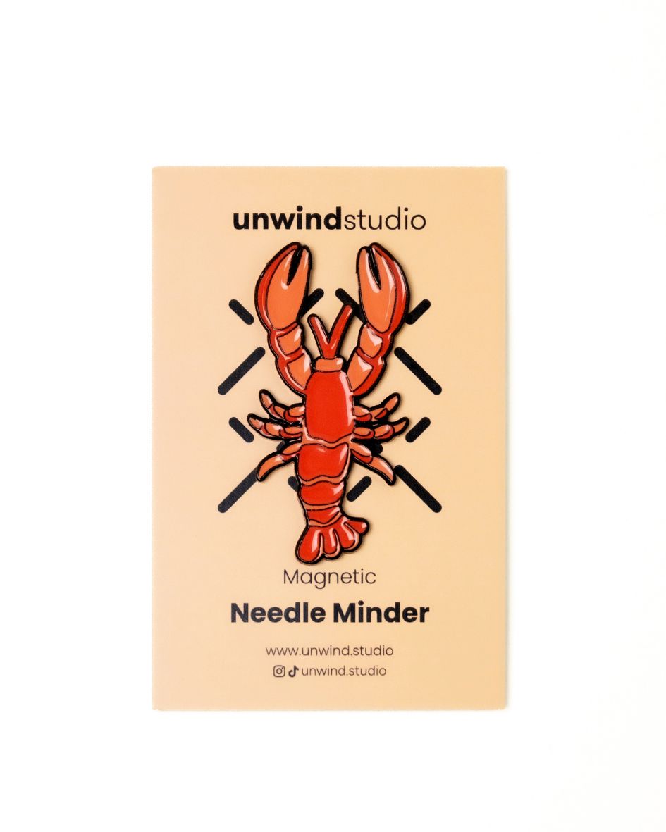 The unwind studio needle minder lobster magnet place on a personalized card.