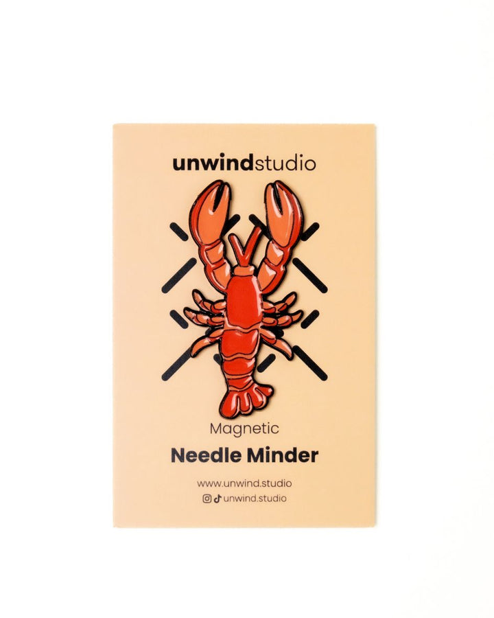 The unwind studio needle minder lobster magnet place on a personalized card.