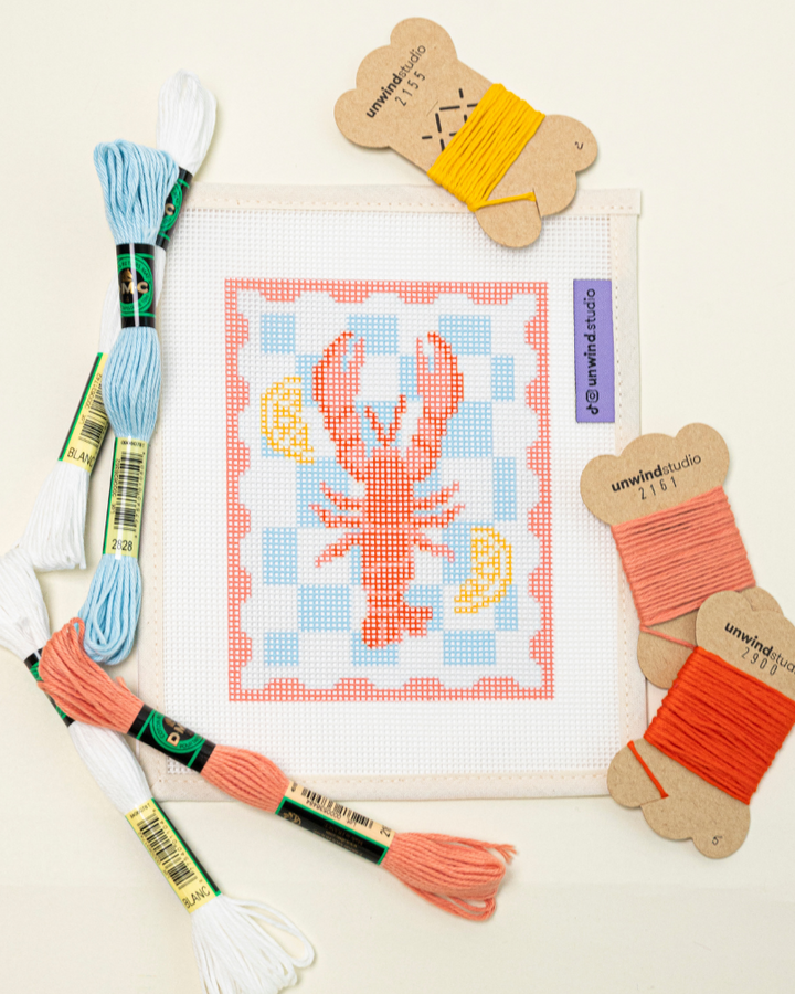 flat lay of the unwind studio lobster stamp with the matching DMC soft cotton threads.