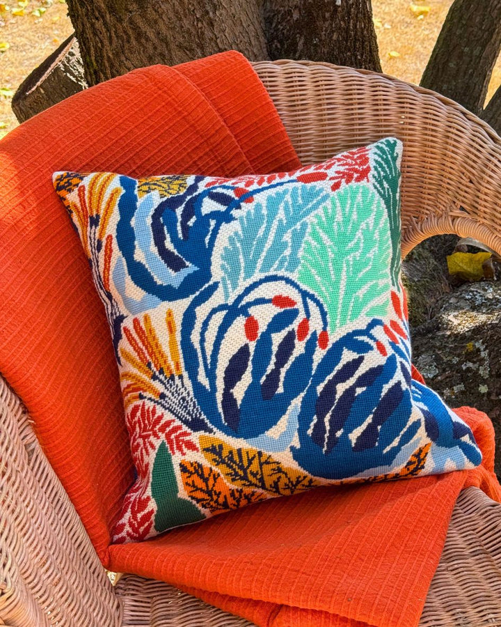 finished meadow cushion placed on a garden chair with an orange blanket.